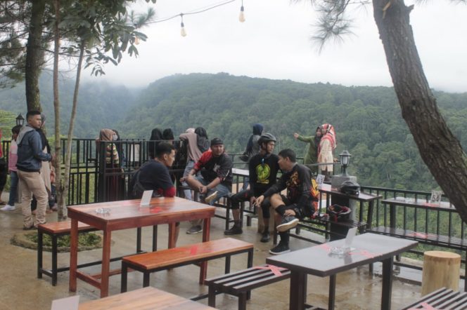 
 Pengunjung menikmati pemandangan alam dan berfoto ria di ketinggian di Elji Kafe Lingkung Gunung di Jalan Caringin Cileungsi, No88 Ciherangsatim, Pancawati, Kecamatan Caringin, Kabupaten Bogor.