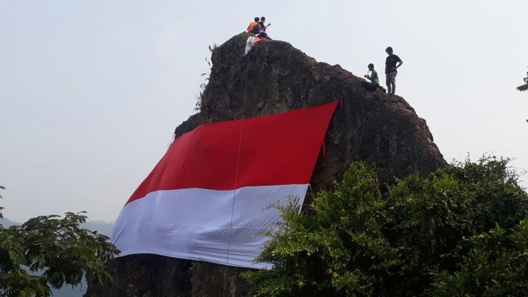 Kereen! Bendera Raksasa Berhasil Dikibarkan di Puncak Gunung Munara