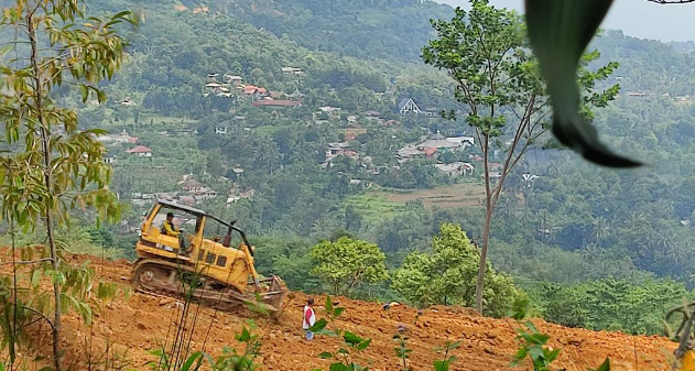
 Sebuah alat berat terlihat tengah melakukan penggusuran tanah di lahan yang diduga milik Sentul City. Kendati demikian aktivitas tersebut ditolak warga karena khawatir mengimbulkan longsor di pemukiman warga.(Istimewa/Bogordaily.net)