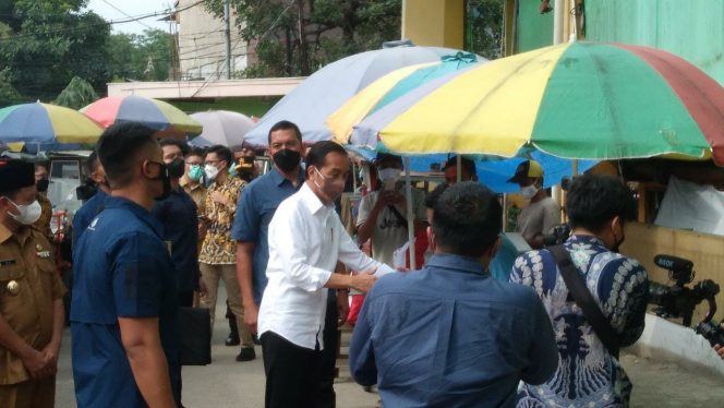 
 Presiden Jokowi sedang membagikan bantuan kepada para PKL di Pasar Cibinong, Kabupaten Bogor, Selasa 17 Mei 2022. (Albin/Bogordaily.net)