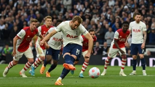 
 Striker Tottenham Hotspur Harry Kane (tengah) mencetak gol pembuka dari titik penalti pada pertandingan antara Tottenham Hotspur vs Arsenal di Stadion Tottenham Hotspur di London, Jumat 13 Mei 2022. (Glyn Kirk/AFP/Suara.com/Bogordaily.net)