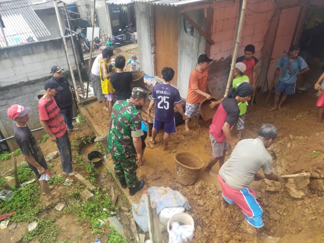 
 Babinsa Kelurahan Ciparigi Peltu Selamet Hariadi bersama warga bergotong royong bersihkan tumpukan tanah akibat bencana tanah longsor.(Istimewa/Bogordaily.net)