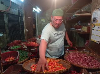 Pedagang cabai dan tomat, Lukman Nulhakim saat merapikan barang dagangannya. (Heri/Bogordaily.net)
