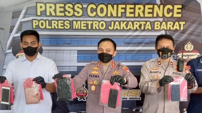 
 Polisi memperlihatkan barang bukti dalam ungkap kasus pornografi lewat media sosial Mango Live di Polres Metro Jakarta Barat, Rabu (6/7/2022). [Suara.com/Faqih Fathurrahman]