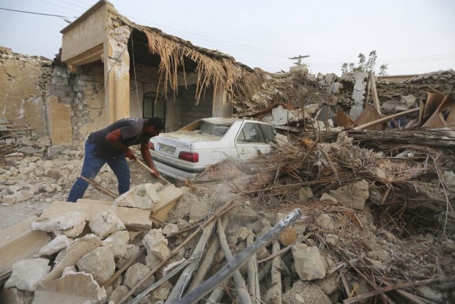   Warga Iran sedang membersihkan puing-puing akibat gempa di Desa Sayeh Khosh Provinsi Hormozgan, Iran, Sabtu 2 Juli 2022. (AP Photo/Bogordaily.net)
