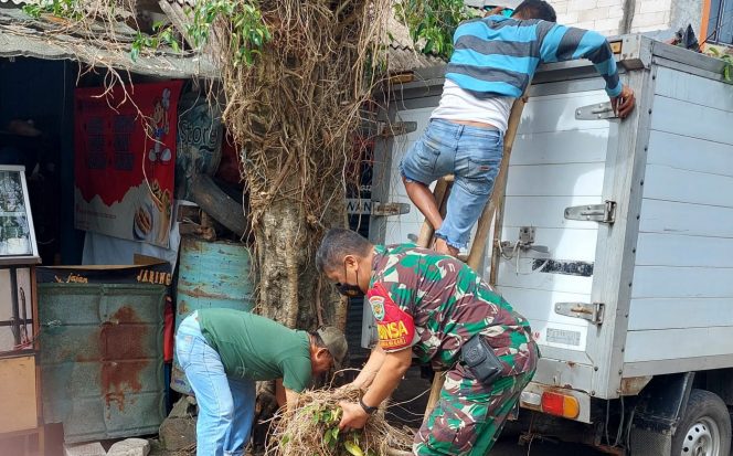 
 Babinsa Kelurahan Rangga Mekar melakukan kerja bakti bersama warga dengan melakukan pemangkasan pohon di Jalan Cipinang Gading. (Istimewa/Bogordaily.net)